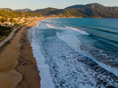 Sahil yolu boyunca sakin bir sahil boyunca dalgalar kıyıya doğru akıyor..