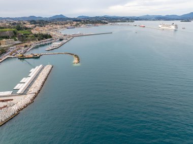 Tekneleri ve yolcu gemisi olan bir liman manzarası..