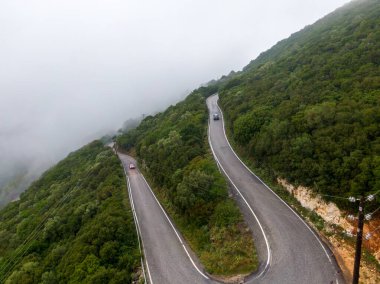 Sisli bir günde, dönen dağ yolu, giden arabalar....