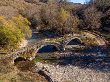 Yunanistan 'ın Epirus kentindeki geleneksel Mylos Köprüsü' nün sonbaharda insansız hava aracı görüntüsü