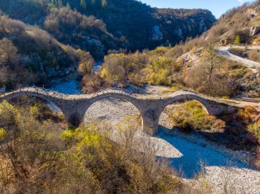 View of the traditional stone Kalogeriko or Plakidas bridge in Zagori of Epirus, Greece in Winter clipart