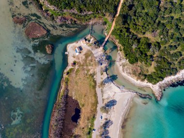 Dar bir kanala ve sakin sulara sahip sakin bir kıyı koyunun havadan görünüşü.