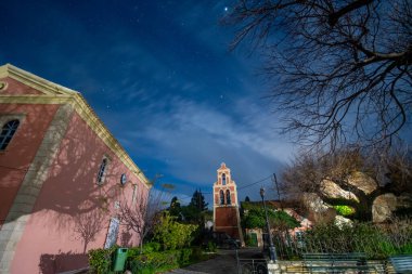 Yıldızlı gökyüzünün altındaki bir kilisenin huzur dolu gece manzarası.