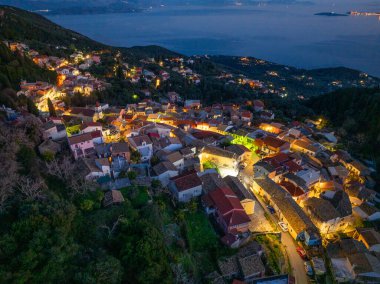 Gece aydınlanan büyüleyici bir köy, sakin bir denize bakan bir yamaçta yuva yapmış..