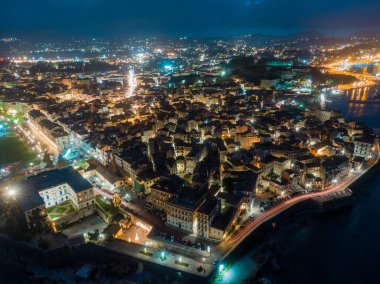 Mimarisini ve sokaklarını gözler önüne seren, aydınlatılmış bir sahil şehrinin gece görüşü.