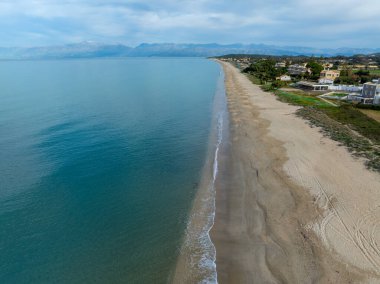 Sakin sahil manzarası, kumlu sahil ve sakin mavi su..