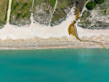 Turkuaz okyanusa akan bir derenin havadan görünüşü.