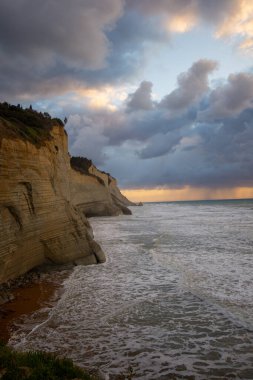 Dramatik sahil kayalıkları fırtınalı bir gökyüzünün altında huzursuz bir denizle karşılaşır..