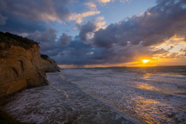 Dramatik sahil uçurumlarında gün batımı ve huzursuz bir deniz..
