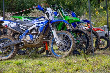 Korfu, korfu, Yunanistan. 09 Şubat 2025 Çimenli bir araziye park edilmiş çamurlu motokros motosikletleri.