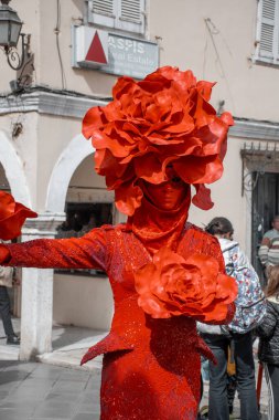 Korfu, korfu, Yunanistan. 10 Mart 2024: Kırmızı gül kostümlü bir sokak sanatçısı