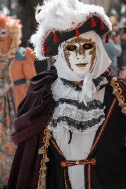 Venedik Karnaval eğlendiricisi, süslü kostüm ve süslü maske içinde, şenlik ruhunu somutlaştırıyor.
