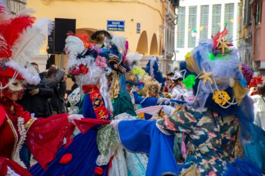 Canlı karnaval kostümleri ve süslü başlıklarla süslenmiş insanlarla şenlikli bir kutlama..