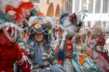 Şenlikli bir kutlama sırasında kostümler ve tüylü şapkalar şehir sokaklarında geçit yapıyor..