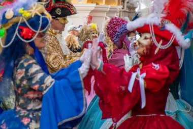 Festivalde, karmaşık maskeler ve tarihi kostümler giyen katılımcılar.
