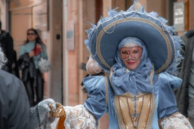 Venedik sokak festivali ya da karnavalında özenle hazırlanmış mavi kostüm ve maske giymiş biri..