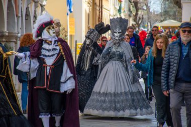 İnsanlar sokak karnavalı ya da festival geçidi sırasında maskeli kostümlerle kutlama yapıyorlar..