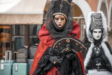 Karmaşık kostümlerle süslenmiş büyüleyici maskeli figürler entrika ve gizemi çağrıştırıyor, zamansız bir gösteri..