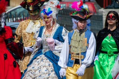 Süslü, tarihi kostümler ve maskeler içinde bir grup, canlı renkler ve ayrıntılı tasarımlarla kutluyorlar..