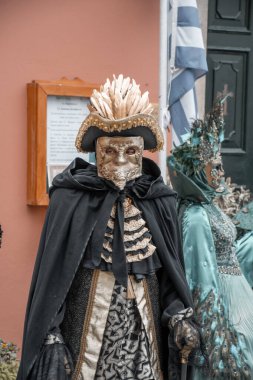 Gösterişli kostümlü maskeli eğlence düşkünü, tarihi ve gizemi harmanlayan canlı festivalin ortasında göze çarpıyor..