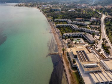 Modern binaların, sahil kenarının ve turkuaz suların bulunduğu bir sahil beldesinin havadan görünüşü..