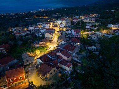 Gece hava manzarası, resimli bir manzaranın ortasına kurulmuş büyüleyici bir köy ve ışıklarla aydınlatılıyor..