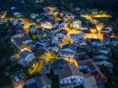 Büyüleyici, eski bir köyün havadan görünüşü yemyeşil bir ortamda, alacakaranlıkta sıcak ışıklarla aydınlanıyor..