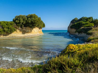 Yunanistan 'ın Korfu kentindeki Kanal d' Amour kıyı şeridi, yeşil kayalıklar ve berrak turkuaz sularla çevrili..