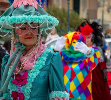 Korfu, korfu, Yunanistan. 02 Mart 2025: Deniz mavisi elbiseli ve maskeli kadın karnaval kutlamasında.