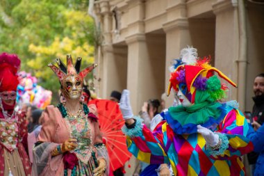 Maskeler ve kostümler şenlik ruhu ve renkleriyle dolu canlı bir sokak geçidini süslüyor..
