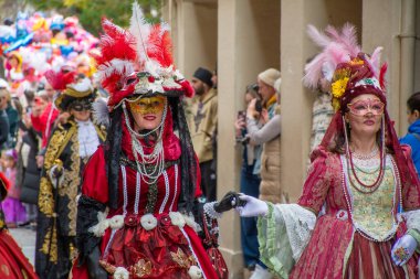 Kalabalık bir geçit töreninde maskeli balo kostümleri açık hava festivalini kutluyor..