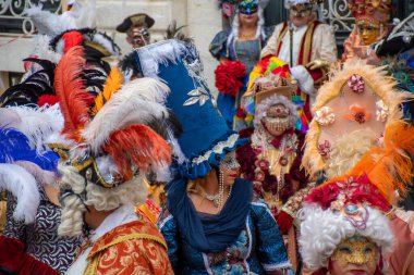 Gösterişli maskeler ve kostümler kalabalığı süslüyor, maskeli balonun ruhunu yakalıyor..