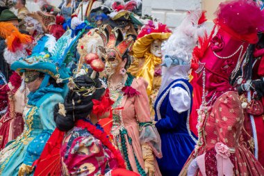 Canlı bir grup, kültür ve sanatın ihtişamını kutlamak için ayrıntılı maskeler ve kostümler sergiliyor..