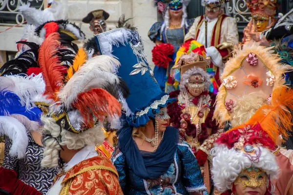 Gösterişli maskeler ve kostümler kalabalığı süslüyor, maskeli balonun ruhunu yakalıyor..