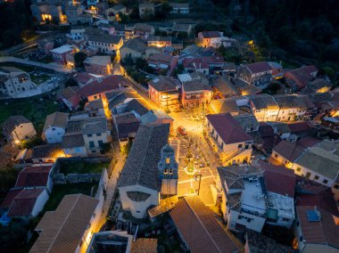 Alacakaranlıktaki tuhaf bir Avrupa kasabasının havadan görünüşü, mimariyi ve caddeleri aydınlatan ışıklar.