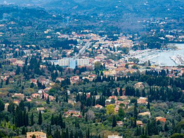 Yükselmiş, uzak bir Avrupa yamaç kasabası manzarası, uzak bir limana doğru uzanan binalar ve yeşillikler..