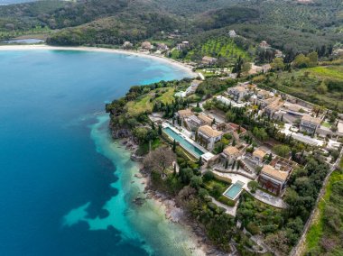 Bu göz hizasında birçok villası, havuzu, bahçesi, plajı ve turkuaz denizi olan bir yamaç arazisi var. Dağlar yemyeşil bir zemin oluşturur..