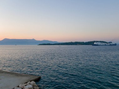 Korfu, korfu, Yunanistan. 15 Ağustos 2020: Bir Grimaldi Hattı feribotu gün batımında bir Yunan adasının yanından geçiyor.