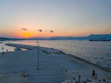 Korfu, korfu, Yunanistan. 15 Ağustos 2020: Bir Yunan limanında büyük bir feribot geçerken gün batımı.