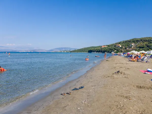 Korfu, korfu, Yunanistan. 23 Ağustos 2020: Sahile gidenler güneşli bir yaz gününde bir Yunan plajının berrak sularının ve kumlu sahillerinin tadını çıkarıyorlar.