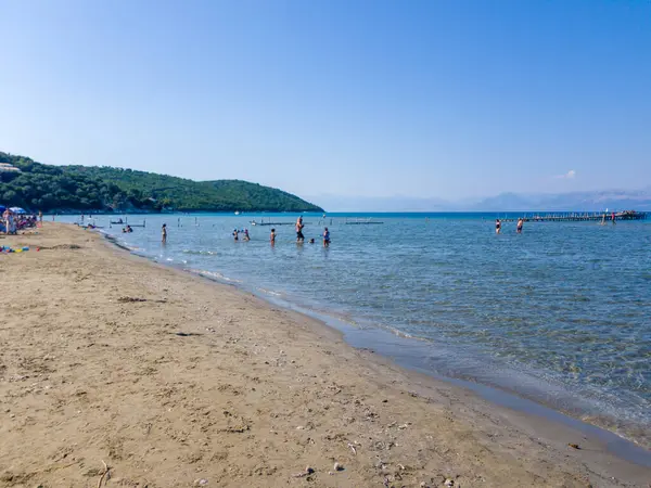 Korfu, korfu, Yunanistan. 23 Ağustos 2020: Sahile gidenler, yaz mevsiminde popüler bir yer olan pitoresk bir plajın sakin sularının ve kumlu sahillerinin tadını çıkarıyorlar..