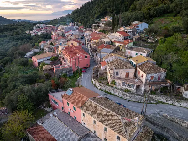 Bu hava görüntüsünde bir yamaç köyü var ve binalar çok sıkı korunuyor. Dolambaçlı yollar, kırmızı fayanslı çatılar ve yemyeşil alanlar gösteriyor..