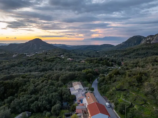 Gün batımında bir vadinin nefes kesici panoramik görüntüsü, doğanın güzelliğini, sakin bir okyanusu ve kırsal binaların kırsal cazibesini gözler önüne seriyor..