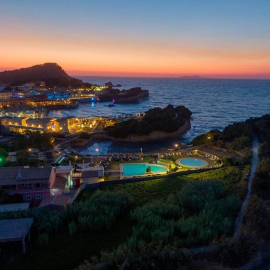 Resmedilmeye değer bir sahil köyü alacakaranlığın yumuşak parıltısıyla yıkanır, sakin okyanus sularının ortasındaki sönen ışığı yansıtan havuzlarla..