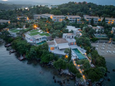 Kalın ağaçların arasına yerleştirilmiş lüks villalar, alacakaranlıkta deniz kenarında özel havuzlar, huzurlu bir kaçış sunuyor..