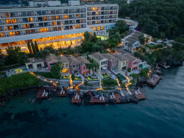 Kıyı şeridinde havuzları olan çok katlı bir otel ve renkli villaların yer aldığı geniş bir tatil köyü, alacakaranlıkta havadan çekilmiş..