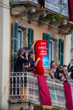Aşağıdan yakalanan insanlar, Yunanistan 'ın Korfu kentinde düzenlenen geleneksel bir Paskalya kutlaması olan süslemeli kırmızı kil çömlekleri eziyorlar. Görüntüleyiciler fotoğrafı.