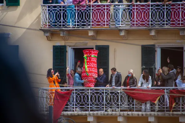 Görüntü, balkondaki bir grup insanı açık hava kutlamalarının bir parçası olarak büyük bir vazoyu düşürmeye hazırlanırken gösteriyor..
