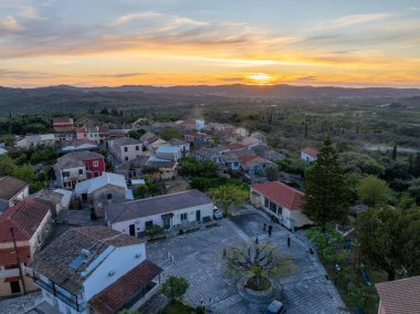 Korfu, korfu, Yunanistan. 19 Nisan 2025: Gün batımında pitoresk bir köyün hava görüntüsü.