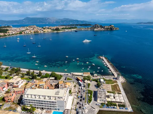 Hava perspektifi, hareketli bir kıyı şehrini, teknelerle dolu ve manzaralı bir dağ zeminiyle çevreleyen hareketli bir limanı yakalıyor..